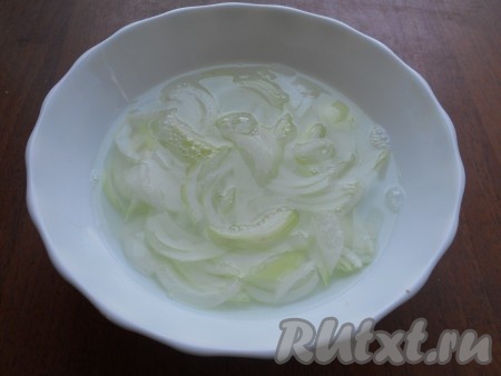 Лук репчатый нарезать тонкими полукольцами, залить кипятком на 30 секунд, затем воду слить. В лук влить уксус, перемешать и оставить мариноваться на 20 минут.
