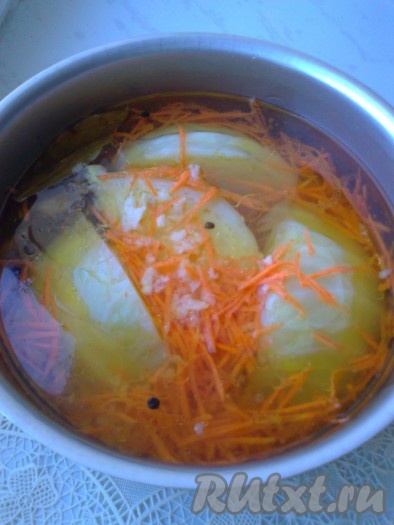 Варим маринад. Для этого кипятим воду, в нее кладем все ингредиенты для маринада и кипятим пару минут, затем снимаем с огня. В горячий маринад добавляем морковь и кориандр. Оставляем до остывания. В подходящую ёмкость выкладываем капусту в один слой, посыпаем её чесноком и заливаем холодным маринадом с морковью и кориандром.
