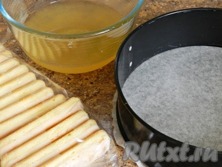 Форму для выпечки застелить бумагой. Часть персикового сиропа, а именно 350 мл отложить, остальной сироп использовать для пропитки печенья или бисквита.