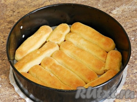 Печенье савоярди окунать в сироп и выкладывать плотно на дно формы. В зависимости от того, круглая форма или прямоугольная и каков ее диаметр, может понадобиться разное количество печенья.
