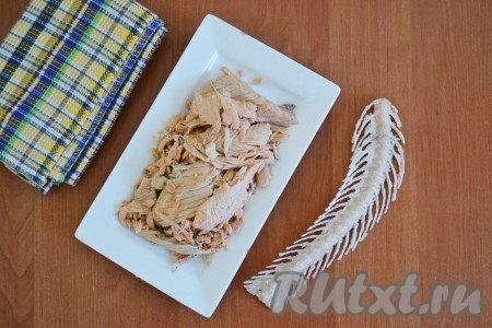 Вынуть хребты из бульона и отделить мясо от костей. Бульон процедить, чтобы случайно не осталось косточек и поставить снова на огонь.
