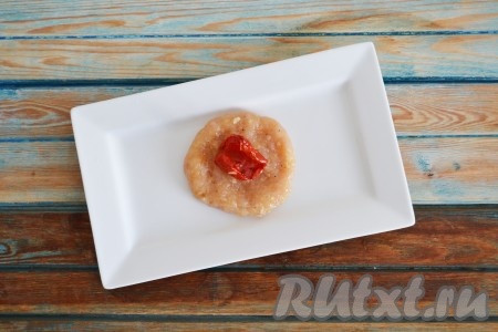 Влажными руками из небольшого количества фарша сформировать котлетку. Если Вы хотите сделать куриные котлеты с начинкой, то получившуюся котлету нужно приплюснуть, чтобы получилась лепешка, в центр которой выложить один кусочек вяленого помидора (или другую начинку).
