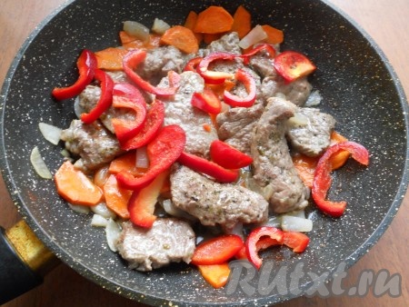 Далее добавить нарезанную тонкими полукружочками морковь. Обжарить все на небольшом огне, периодически перемешивая, около 5-7 минут. Затем добавить в сковороду нарезанный соломкой болгарский перец.
