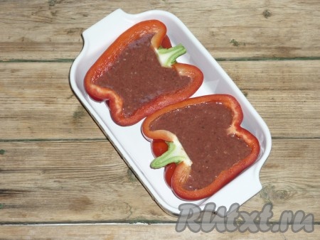 Половинки перца уложить в форму для запекания, заполнить их начинкой из печени.
