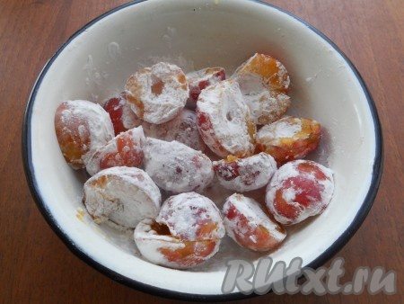 Сливы разделить на две половинки, удалить косточки. Для этой выпечки желательно брать сладкие сливы и яблоко. Если же фрукты кисловаты, тогда можно добавить в тесто 1 столовую ложку сахара. Обвалять половинки слив в картофельном (или кукурузном) крахмале со всех сторон. Благодаря крахмалу, сок, который выделится из слив в процессе выпечки, будет желироваться, а значит не будет делать выпечку излишне влажной.