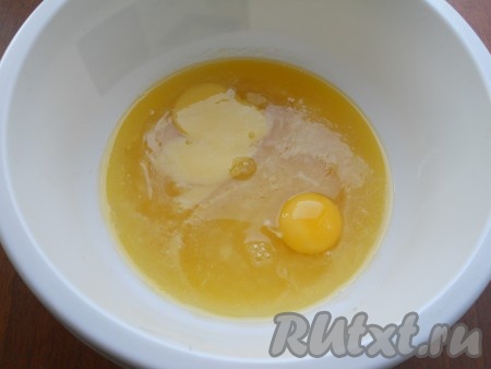 В миску с растопленным маслом всыпать сахар, перемешать. Добавить яйца, взбить миксером до белой пены.