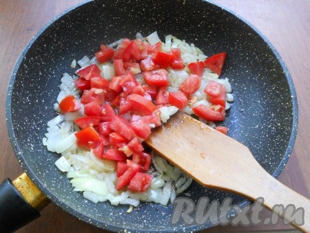 В сковороде прогреть растительное масло, выложить очищенный и мелко нарезанный лук, обжарить его на среднем огне до прозрачности (в течение 3-4 минут), иногда помешивая. Помидоры, по желанию, очистить от кожуры, нарезать на небольшие кубики. После того как лук обжарится до прозрачности, добавить к нему нарезанные помидоры, перемешать. Обжарить овощи в течение 2-3 минут (помидоры должны стать достаточно мягкими), периодически перемешивая.
