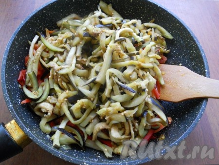 Баклажаны хорошенько отжать от жидкости и добавить в сковороду с обжаренными овощами.