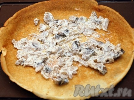 Остывшую начинку из грибов раскладываем на более обжаренную сторону блина.