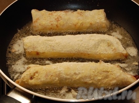 На сковороду с раскалённым растительным маслом кладём наши рулетики из блинов с грибами, расположив их так, чтобы они не касались друг друга.