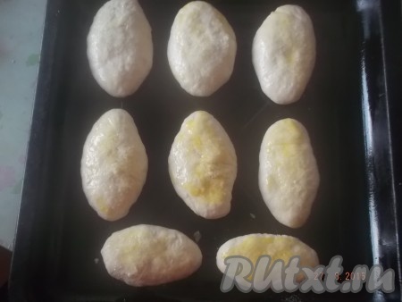 Складываем пирожки со сливами на смазанный маслом противень вниз швом. Смазываем сырым яйцом и посыпаем сахаром.&nbsp;
