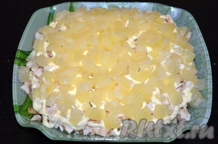 Далее идёт слой отварной курицы, по желанию, посолить и поперчить. Смазать майонезом. Затем выложить ананасы. Майонезом промазывать не нужно.