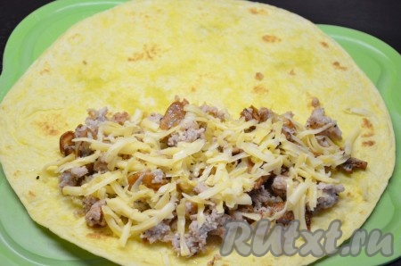 На одну половинку мексиканской пшеничной лепешки выложить половину начинки, посыпать сыром и накрыть другой половинкой лепешки. Чтобы начинка не выпала, я скрепила края лепешки зубочистками. &nbsp;
