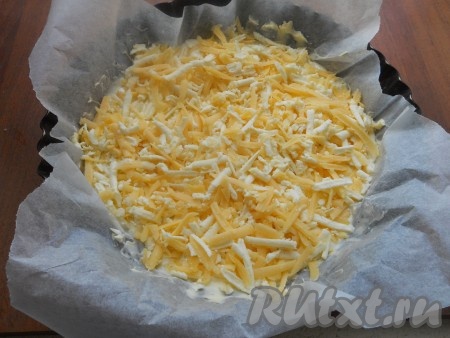 Форму для запекания (диаметром 20 см) застелить пергаментом и смазать его сливочным маслом (можно и не застилать). Половину теста вылить в форму, на тесто выложить смесь сыров.
