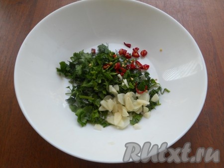 Зелень измельчить, добавить нарезанный тонкими пластинами чеснок и мелко нарезанный перец чили. Перемешать.
