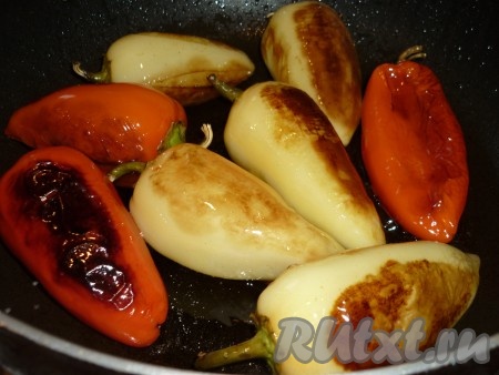 При обжаривании из перца выделяется сок и, попадая в масло, очень сильно брызгает, поэтому нужно открывать крышку очень аккуратно, когда будете переворачивать перцы на другую сторону. Обжаренные перцы сложить на тарелку или в подходящую посуду. Я кожицу с перца не снимала, но, по желанию, можно снять. Для того чтобы легче было снять кожицу, обжаренные перцы нужно поместить в ёмкость, накрыть крышкой, дать немного остыть, затем очистить от плёнки, покрывающей их сверху. Перцы, жареные целиком на сковороде, особенно вкусно подать с помидорами, тушеными с луком.
