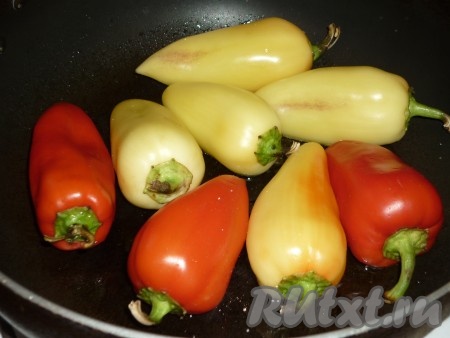 Болгарские перцы вымыть под холодной проточной водой, обсушить бумажным полотенцем. Сковороду с растительным маслом разогреть и выложить перцы целиком. Масло должно покрывать дно сковороды полностью. Сковороду накрыть крышкой и обжарить перцы по 3-4 минуты с каждой стороны на среднем огне.
