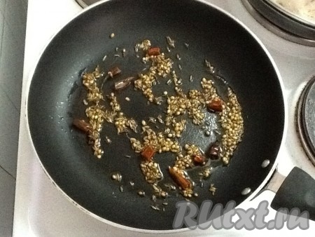 На другой сковороде разогреть еще 2 столовые ложки масла, добавить зиру, кориандр и фенхель. Перчики чили поломать на кусочки и добавить туда же. Обжарить, иногда перемешивая.