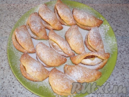 Готовое печенье достать из духовки, слегка остудить, переложить на блюдо и щедро посыпать сахарной пудрой.