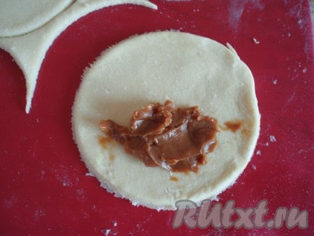 На одну половинку кружочка выложить примерно 0,5 чайной ложки варёной сгущёнки, не забывая отступить от краёв кружка. Со сгущёнкой лучше не переборщить, чтобы во время выпечки она не вытекала.