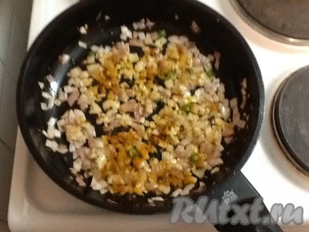 Когда лук слегка поджарится, добавить натертый имбирь и пропущенный через пресс чеснок, зеленый перчик чили и, помешивая, готовить одну минуту. Затем добавить порошок куркумы и семена кориандра, посолить.
