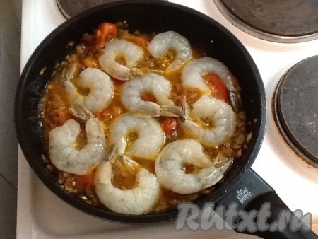 Долить 50 мл воды, довести до кипения и выложить креветки. Через пару минут креветки перевернуть и потушить еще 2 минуты.