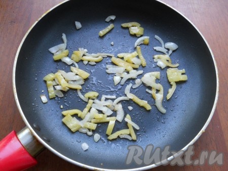 В сковороду влить оставшееся растительное масло, добавить лук и сладкий перец. Обжарить овощи на небольшом огне до мягкости, иногда помешивая.
