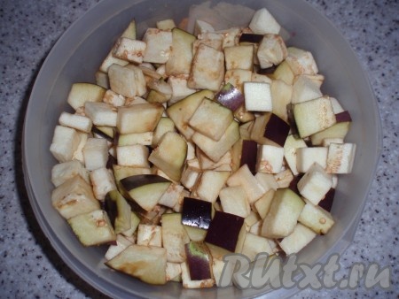 Баклажаны нарезать кубиками. В сковороде нагреть 2 столовые ложки растительного масла, всыпать баклажаны и обжарить, перемешивая, в течение 5 минут.
