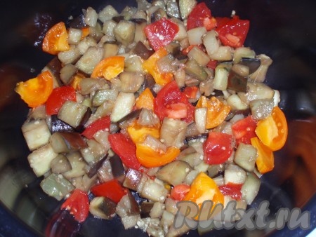 Выставить режим мультиварки «Выпечка» на 35 минут. Обжаренные баклажаны переложить в чашу мультиварки. Туда же добавить нарезанные кубиками помидоры.
