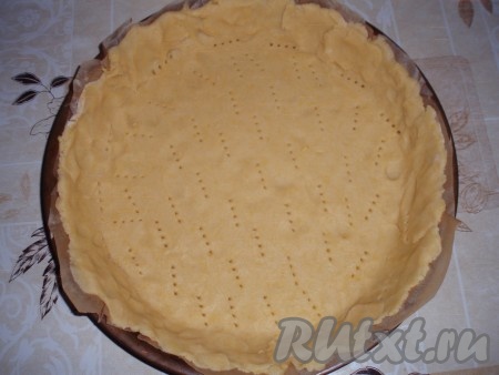 Охлажденное тесто раскатать, выложить в форму для выпечки с невысокими бортиками. Наколоть тесто вилкой.
