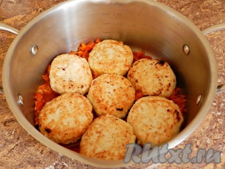 В кастрюлю с толстым дном выложить половину овощной заправки. На заправку выложить обжаренные ленивые голубцы.
