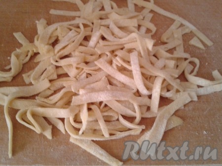 Тесто должно быть хорошо посыпанным мукой, чтобы при нарезке лапша не слипалась. Нарезаем тесто соломкой (длину и ширину домашней лапши можно делать произвольной, на ваше усмотрение). Нарезанную лапшу можно добавлять в процессе приготовления первых блюд (она станет отличной альтернативой макаронным изделиям). А я предлагаю подать её со сливочным маслом на гарнир или в качестве самостоятельного блюда.