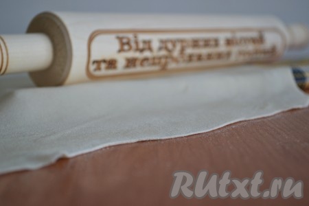 По истечении времени одну часть теста раскатать очень тонко, толщиной 1 мм. Это придется делать с небольшим усилием.
