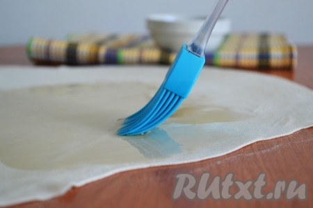 С помощью кисточки смазать тесто вытопленным жиром. Именно это и позволит пластам теста не слипнуться друг с другом, а выпечке - в результате стать слоеной. Жир должен быть теплым, но не горячим и не холодным. Впрочем, холодным невозможно смазать, так как он быстро застывает.
