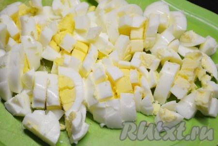 Свареные вкрутую яйца очистить и нарезать кубиками.
