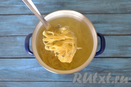 В отдельной кастрюле в кипящей подсоленной воде отварить длинную лапшу. Она должна быть "аl dente" - на зубок, немного недоваренная. Для этого понадобится 5-7 минут. Я использовала покупную длинную лапшу, но ее можно заменить другой любимой пастой или сделать своими руками. Для того чтобы сделать лапшу своими руками, необходимо 3 куриных яйца вбить в миску, добавить щепотку соли и щепотку куркумы, немного разболтать вилкой и начать небольшими порциями всыпать просеянную муку. Так как куриные яйца разного размера, то сложно указать количество муки, примерно 250-320 грамм. Замесить тесто, оно должно стать мягким, не липнущим к рукам и очень покладистым, как размягченный детский пластилин. Затем дать тесту отдохнуть 10 минут под салфеткой. Скалкой раскатать тесто в пласт толщиной в 2 мм и нарезать длинными полосками шириной в 5 мм. Каждую полоску скрутить гнездом и оставить на столе подсыхать, пока готовятся мясо с овощами, а затем отварить в течение 5-7 минут в кипящей подсоленной воде. 