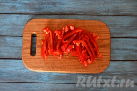 Перец вымыть, удалить плодоножку, семена и нарезать тонкой соломкой.
