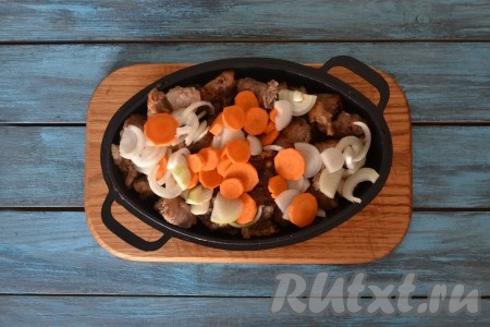 Выложить лук с морковью к обжаренным кусочкам баранины, перемешать и готовить 2-3 минуты на слабом огне, иногда помешивая.
