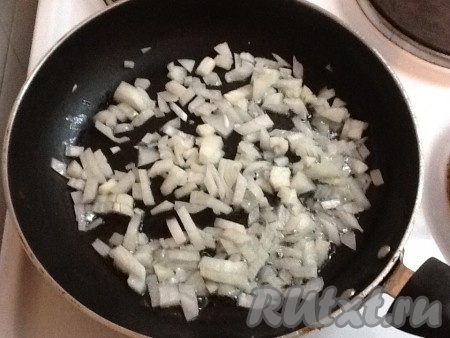 Поставить сковородку на плиту, добавить пару столовых ложек растительного масла и разогреть. Выложить нарезанный лук и обжарить, иногда помешивая, в течение 3 минут.

