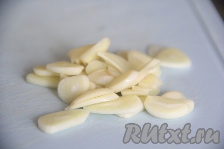 Чеснок очистить и нарезать тонкими лепестками.