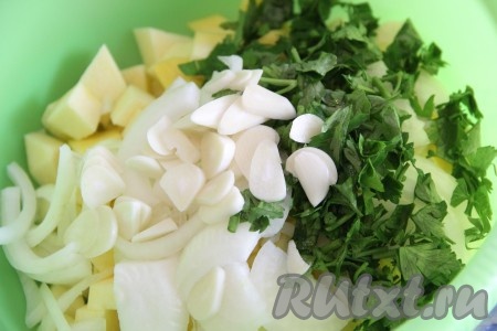 Добавить к тыкве измельчённую зелень, нарезанные чеснок и лук.
