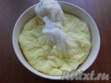 Подвесить марлю с творогом, чтобы лишняя жидкость стекла. Когда творог остынет, отжать его. Поместить творог в марле в подходящую по размеру глубокую посуду.