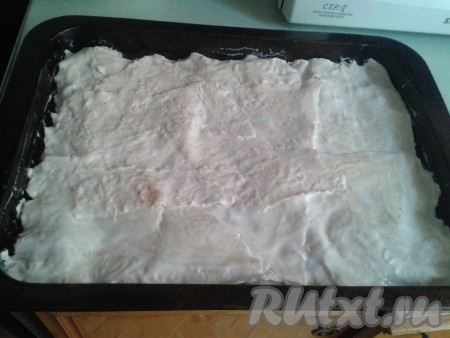 Дальше нужно подготовить лаваш, для этого его нужно окунуть в кефир. Лаваш должен пропитаться с двух сторон. Затем пропитанный лаваш выложить на помидоры. Лаваш должен покрывать всю запеканку, можно делать несколько слоев лаваша, у меня 2 слоя.