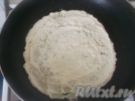 Затем ставим сковороду на средний огонь, разогреваем, наливаем совсем немного масла, только чтобы смочить сковороду, и ложкой выкладываем тесто, размазывая по кругу, чтобы получился блин толщиной примерно 0,5 см.