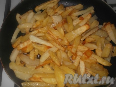 Ставим сковороду на средний огонь, разогреваем масло, выкладываем картофель и жарим до полуготовности, иногда перемешивая, немного присолив.
