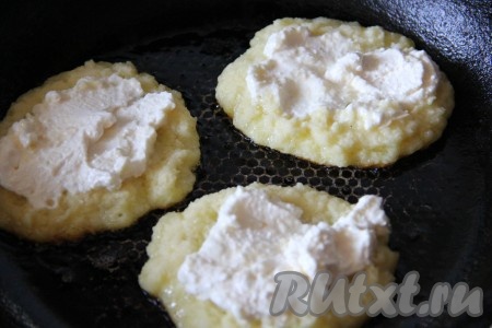 Сверху на картофельный оладушек выложить творог, равномерно распределяя его.
