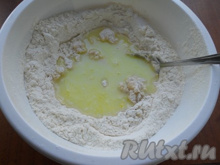 Сюда же добавить дрожжевую смесь и частями вливать оставшуюся сыворотку, замешивая тесто.