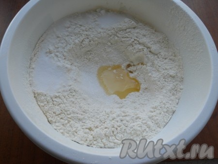 Муку просеять, сделать углубление, в которое всыпать оставшийся сахар, растительное масло и соль.