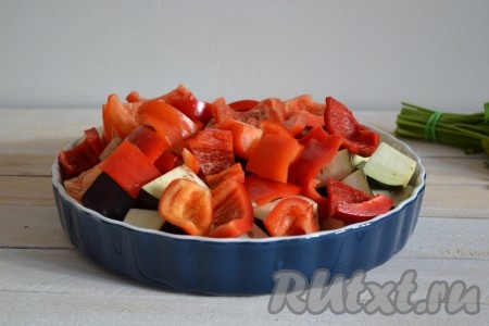 Перцы вымыть, очистить от плодоножки и семян, нарезать крупными кусками (примерно на 4-6 кусочков) и добавить к баклажанам.
