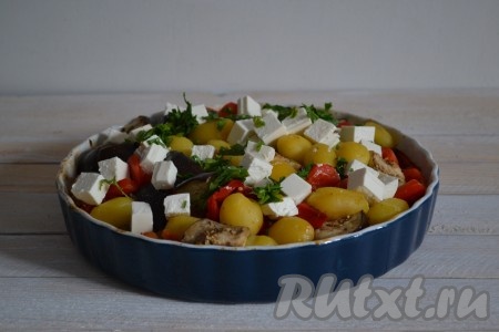 Достать форму из духовки и выложить сверху нарезанный кубиками сыр, добавить, по желанию, зелень и отправить обратно в духовку на 7-10 минут.
